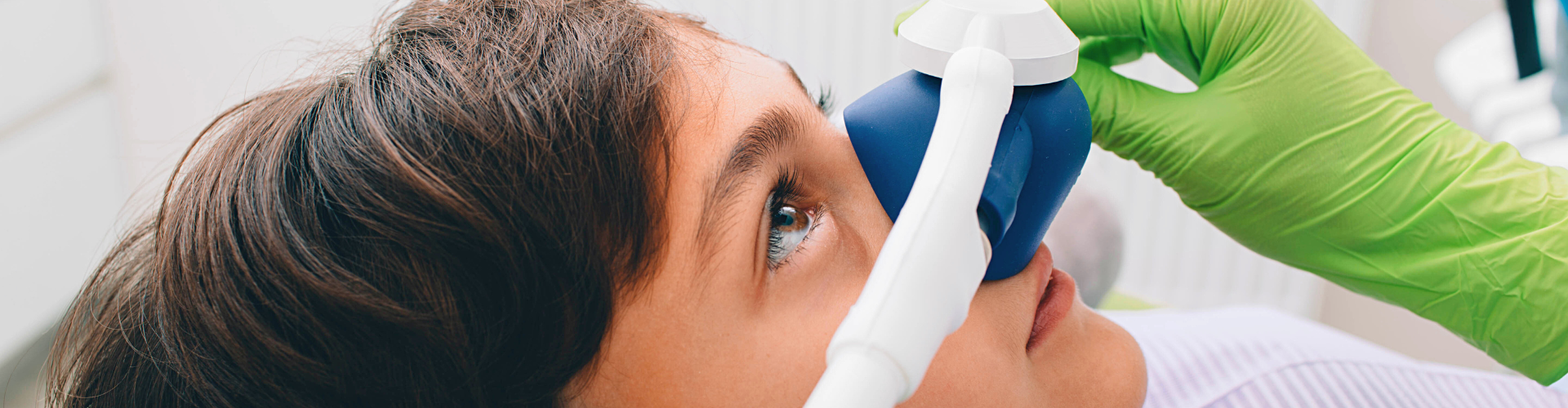 Gloved hands placing breathing mask over boy's nose.